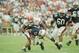 Auburn quarterback Stan White picks up a first down despite Florida end Kevin Carter (57) on his back in second quarter in their SEC game at Auburn, Ala., Oct. 16, 1993. (AP Photo/Jay Sailors)