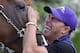 Exercise rider Willie Delgado laughs as he waits to guide Kentucky Derby and Preakness winner California Chrome onto a trailer at Pimlico Race Course in Baltimore, Tuesday, May 20, 2014. The horse is headed to Belmont Park in Elmont, N.Y, where the Belmont Stakes horse race is scheduled to take place June 7. (AP Photo/Patrick Semansky)