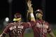 Florida State catcher Danny De La Calle (13) exchanges high-fives with pitcher Jameis Winston (44) after defeating Virginia 6-4 in the Atlantic Coast Conference college baseball tournament in Greensboro, N.C., Saturday, May 24, 2014. (AP Photo/Bob Leverone)