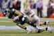 FILE - In this Dec. 7, 2013 file photo, Michigan State's Connor Cook (18) is sacked by Ohio State's Joey Bosa (97) during the first half of a Big Ten Conference championship NCAA college football game in Indianapolis. With Bosa, Noah Spence, Adolphus Washington and Michael Bennett up front and quality players behind them, the Buckeyes are hoping to erase the memory of a porous final few games in the 2013 season. (AP Photo/Darron Cummings, File)
