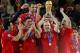 Spain's Andres Iniesta, second from right, holds up the World Cup trophy as team members celebrate at the end of the World Cup final soccer match between the Netherlands and Spain at Soccer City in Johannesburg, South Africa, Sunday, July 11, 2010. Spain won 1-0. (AP Photo/Bernat Armangue)