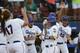 Florida's Kirsti Merritt, center, is greeted by her teammates at home plate following her home run in the second inning of an NCAA Women's College World Series softball tournament game against Alabama in Oklahoma City, Tuesday, June 3, 2014. (AP Photo/Sue Ogrocki)