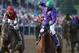 Jockey Victor Espinoza, center, aboard California Chrome, celebrates after winning the 139th Preakness Stakes horse race at Pimlico Race Course, Saturday, May 17, 2014, in Baltimore. Ride On Curlin, left, ridden by Joel Rosario, finished second. (AP Photo/Matt Slocum)