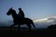 Rain clouds roll past Belmont Park as an exercise rider takes a thoroughbred out for a workout in the track, Wednesday, June 4, 2014, in Elmont, N.Y. Kentucky Derby and Preakness Stakes winner California Chrome will attempt to become the first Triple Crown winner since Affirmed in 1978 when he races in the 146th running of the Belmont Stakes horse race on Saturday. (AP Photo/Julie Jacobson)