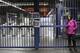 A commuter stands at the closed Belem metro station where a sign hangs that reads in Portuguese