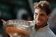 Spain's Rafael Nadal bites the trophy after winning the final of the French Open tennis tournament against Serbia's Novak Djokovic at the Roland Garros stadium, in Paris, France, Sunday, June 8, 2014. Nadal won in four sets 3-6, 7-5, 6-2, 6-4. (AP Photo/Darko Vojinovic)