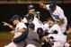 UC Irvine players celebrate following an NCAA college baseball tournament super regional game against Oklahoma State in Stillwater, Okla., Saturday, June 7, 2014. UC Irvine won 1-0 to move on to the College World Series in Omaha. (AP Photo/Sue Ogrocki)
