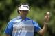 Bubba Watson acknowledges the patrons after making a putt on the second hole during the final round of the Memorial golf tournament on Sunday, June 1, 2014, in Dublin, Ohio. (AP Photo/Darron Cummings)