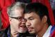CORRECTS PACQUIAO TO RIGHT, NOT LEFT - Manny Pacquiao, right of the Philippines, right, listens to his trainer Freddie Roach, during a boxing news conference, Tuesday, Feb. 4, 2014, in Beverly Hills, Calif., to promote their upcoming WBO welterweight championship boxing rematch against Tim Bradley. Pacquiao and Bradley's first match on June 9, 2012 was a split decision in favor of Bradley, which ended Pacquiao's welterweight title reign as well as his seven-year, 15-bout winning streak. Pacquiao vs. Bradley 2 will take place Saturday, April 12, 2014, in Las Vegas. (AP Photo/Reed Saxon)