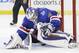 A shot on goal by the Los Angeles Kings slips through the legs of New York Rangers goalie Henrik Lundqvist (30) to rest near the goal line before being swatted out by Rangers center Derek Stepan in the third period during Game 4 of the NHL hockey Stanley Cup Final, Wednesday, June 11, 2014, in New York. The Rangers won 2-1. (AP Photo/Seth Wenig)