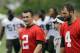 Cleveland Browns quarterback Johnny Manziel (2) walks off the field with Tyler Thigpen (4) and quarterbacks coach Dowell Loggains after a mandatory minicamp practice at the NFL football team's facility in Berea, Ohio Thursday, June 12, 2014. (AP Photo/Mark Duncan)