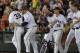 Virginia players celebrate with Mike Papi, left, who hit a double in the ninth inning against Mississippi that scored Thomas Woodruff to win an NCAA baseball College World Series game in Omaha, Neb., Sunday, June 15, 2014. Virginia won 2-1. Second left is Austin Young, third left is Nate Irving. (AP Photo/Ted Kirk)