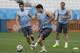 Uruguay national soccer team player Luis Suarez, center, passes a ball as he takes part in a squad training session for the 2014 soccer World Cup at Itaquerao Stadium in Sao Paulo, Brazil, Wednesday, June 18, 2014. Uruguay play England in group D of the 2014 soccer World Cup at the stadium on Thursday. (AP Photo/Matt Dunham)