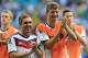Germany's Philipp Lahm, left, and Thomas Mueller applaud after the group G World Cup soccer match between Germany and Portugal at the Arena Fonte Nova in Salvador, Brazil, Monday, June 16, 2014. Germany won the match 4-0. (AP Photo/Bernat Armangue)