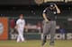 Second base umpire Angel Campos swats at a swarm of moths flying around the field in the eighth inning of a baseball game between the St. Louis Cardinals and the Philadelphia Phillies, Friday, June 20, 2014 in St. Louis. (AP Photo/Tom Gannam)