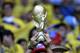 A Columbian fan holds up a replica of the World Cup trophy before the group C World Cup soccer match between Colombia and Greece at the Mineirao Stadium in Belo Horizonte, Brazil, Saturday, June 14, 2014. (AP Photo/Fernando Vergara)