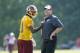 Washington Redskins quarterback Robert Griffin III, left, laughs with head coach Jay Gruden during an NFL football minicamp, Tuesday, June 17, 2014, in Ashburn, Va. (AP Photo/Nick Wass)