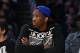 Kansas center Joel Embiid watches the Los Angeles Lakers play the Memphis Grizzlies in an NBA basketball game, Sunday, April 13, 2014, in Los Angeles. The Grizzlies won 102-90. (AP Photo/Mark J. Terrill)