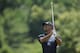 Tiger Woods watches his drive from the driving range as he practices at the Quicken Loans National golf tournament, Tuesday, June 24, 2014, in Bethesda, Md. (AP Photo/Nick Wass)