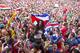 Costa Rica soccer fans celebrate a goal against Greece as they watch the World Cup round of 16 match on TV set up in a public square in San Jose, Costa Rica, Sunday, June 29, 2014. (AP Photo/Esteban Felix)
