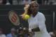 Serena Williams goes to play a return with partner Venus Williams of the U.S in their women's doubles match against Kristina Barrios of Germany and Stefanie Voegele of Switzerland at the All England Lawn Tennis Championships in Wimbledon, London, Tuesday July 1, 2014. The Williams sisters retired after 3 games. (AP Photo/Pavel Golovkin)
