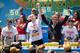 Joey Chestnut, center, wins the Nathan's Famous Fourth of July International Hot Dog Eating contest with a total of 69 hot dogs and buns, alongside Tim Janus, left, and Matt Stonie, right, at Coney Island, Thursday, July 4, 2013, in the Brooklyn borough of New York. (AP Photo/John Minchillo)