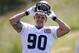 Seattle Seahawks' Jesse Williams pulls on his helmet at an NFL organized team activity football practice Monday, June 2, 2014, in Renton, Wash. (AP Photo/Elaine Thompson)