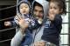 Uruguay's soccer player Luis Suarez holds his children as he greets fans from their home's balcony on the outskirts of Montevideo, Uruguay, Friday, June 27, 2014. Suarez returned to Montevideo early Friday, arriving too late to see the hundreds of Uruguay fans who had gathered the previous night to give him a hero's welcome despite his World Cup banishment. (AP Photo/Matilde Campodonico)