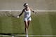 Eugenie Bouchard of Canada hits a ball into the crowd as she celebrates after defeating Simona Halep of Romania in their women's singles semifinal match at the All England Lawn Tennis Championships in Wimbledon, London, Thursday, July 3, 2014. Bouchard will play Petra Kvitova of Czech Republic in the women's final Saturday. (AP Photo/Sang Tan, Pool)