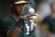 Oakland Athletics shortstop Addison Russell rolls a baseball on his hand in the dugout as the Athletics play the Arizona Diamondbacks in an exhibition spring training baseball game Thursday, March 6, 2014, in Scottsdale, Ariz. (AP Photo/Gregory Bull)