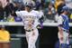 Colorado Rockies' Troy Tulowitzki, front, gestures as he crosses home plate after hitting a solo home run as Los Angeles Dodgers catcher Drew Butera looks on in the fourth inning of a baseball game in Denver on Sunday, June 8, 2014. (AP Photo/David Zalubowski)