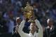 Novak Djokovic of Serbia holds up the trophy after defeating Roger Federer of Switzerland in the men's singles final at the All England Lawn Tennis Championships in Wimbledon, London, Sunday July 6, 2014. (AP Photo/Pavel Golovkin)