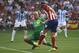 Atletico's Filipe Luis, right, vies for the ball with Malaga's goalkeeper Willy Caballero, left, during their Spanish La Liga soccer match at the Vicente Calderon stadium in Madrid, Spain, Sunday, May 11, 2014. (AP Photo/Gabriel Pecot)