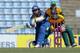 Sri Lankan cricketer Tillakaratne Dilshan bats in front of South African wicketkeeper Quinton de Kock and Jacques Kallis during their second one-day international cricket match in Pallekele, Sri Lanka, Wednesday, July 9, 2014. (AP Photo/Eranga Jayawardena)