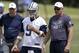 Dallas Cowboys quarterback Tony Romo stands by quarterbacks coach Wade Wilson, right, as they watch the team run drills during an NFL football organized team activity, Tuesday, May 27, 2014, in Irving, Texas. (AP Photo/Tony Gutierrez)