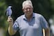 Colin Montgomerie waves his visor at the crowd on the ninth green in the first round of play at the 2014 U.S. Senior Open golf tournament at Oak Tree National in Edmond, Okla., Thursday, July 10, 2014. (AP Photo/Sue Ogrocki)