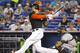 Miami Marlins' Giancarlo Stanton grounds out in the first inning as Atlanta Braves catcher Gerald Laird looks on during a baseball game in Miami, Saturday, May 31, 2014. (AP Photo/Joe Skipper)