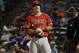Los Angeles Angels' Mike Trout adjust his gloves between pitches from Texas Rangers' Aaron Poreda in the eighth inning of a baseball game, Thursday, July 10, 2014, in Arlington, Texas. (AP Photo/Tony Gutierrez)