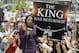Fans whoop it up behind an ESPN reporter outside Quicken Loans Arena in Cleveland, after NBA basketball star LeBron James announced he would return to the Cleveland Cavaliers Friday, July 11, 2014. (AP Photo/Mark Duncan)