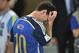 Argentina's Lionel Messi scratches his head as he goes up to get his runners-up medal after the World Cup final soccer match between Germany and Argentina at the Maracana Stadium in Rio de Janeiro, Brazil, Sunday, July 13, 2014. Germany won the match 1-0 (AP Photo/Martin Meissner)