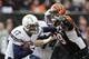 Philip rivers, de los Chargers de San Diego, acarrea el balón y trata de eludir a Margus Hunt, defensive end de los Bengals de Cincinnati, durante el duelo de comodines de la Conferencia Americana, disputado el domingo 5 de enero de 2014 (AP Foto/Al Behrman)