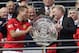 Manchester United's captain Nemanja Vidic, left, passes the trophy to manger David Moyes after their win against Wigan Athletic at the end of their English FA Community Shield soccer match at Wembley Stadium in London, Sunday, Aug. 11, 2013. (AP Photo/Jon Super)