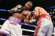 BROOKLYN, NY - AUGUST 9: Lamont Peterson (White w/Purple trunks) lands a body shot to Edgar Santana (Silver w/Red trunks) during their IBF junior welterweight championship fight at the Barclays Center on August 9, 2014 in Brooklyn, New York. (Photo by Ed Mulholland/Getty Images)