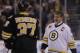 Boston Bruins great Ray Bourque smiles as he passes Patrice Bergeron prior to the first period of an NHL hockey game, Monday, March 24, 2014, in Boston. (AP Photo/Charles Krupa)