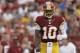 Washington Redskins quarterback Robert Griffin III walks across the field after a play during the first half of an NFL football preseason game against the New England Patriots in Landover, Md., Thursday, Aug. 7, 2014. (AP Photo/Connor Radnovich)