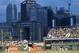 The city skyline is seen behind PNC Park as Pittsburgh Pirates starting pitcher Edinson Volquez, center, throws against the Detroit Tigers in the fourth inning of the baseball game on Tuesday, Aug. 12, 2014, in Pittsburgh. (AP Photo/Keith Srakocic)