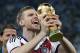 Germany's Per Mertesacker celebrates with the trophy after the World Cup final soccer match between Germany and Argentina at the Maracana Stadium in Rio de Janeiro, Brazil, Sunday, July 13, 2014. Germany won the match 1-0. (AP Photo/Matthias Schrader)