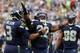 Seattle Seahawks quarterback Russell Wilson, left, celebrates with running back Robert Turbin (22) after Turbin scored a touchdown against the San Diego Chargers in the first half of a preseason NFL football game, Friday, Aug. 15, 2014, in Seattle. (AP Photo/John Froschauer)