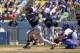 Milwaukee Brewers' Jonathan Lucroy, left, hits a three run double as Los Angeles Dodgers catcher Drew Butera looks on during the second inning of a baseball game, Sunday, Aug. 17, 2014, in Los Angeles. (AP Photo/Mark J. Terrill)