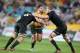 Australia's Nathan Charles, center, charges through the defense of New Zealand's Kieran Read, left, and Brodie Retallic during their Bledisloe Cup rugby union test match in Sydney, Saturday, Aug. 16, 2014. The game is a 12-all draw. (AP Photo/Rick Rycroft)